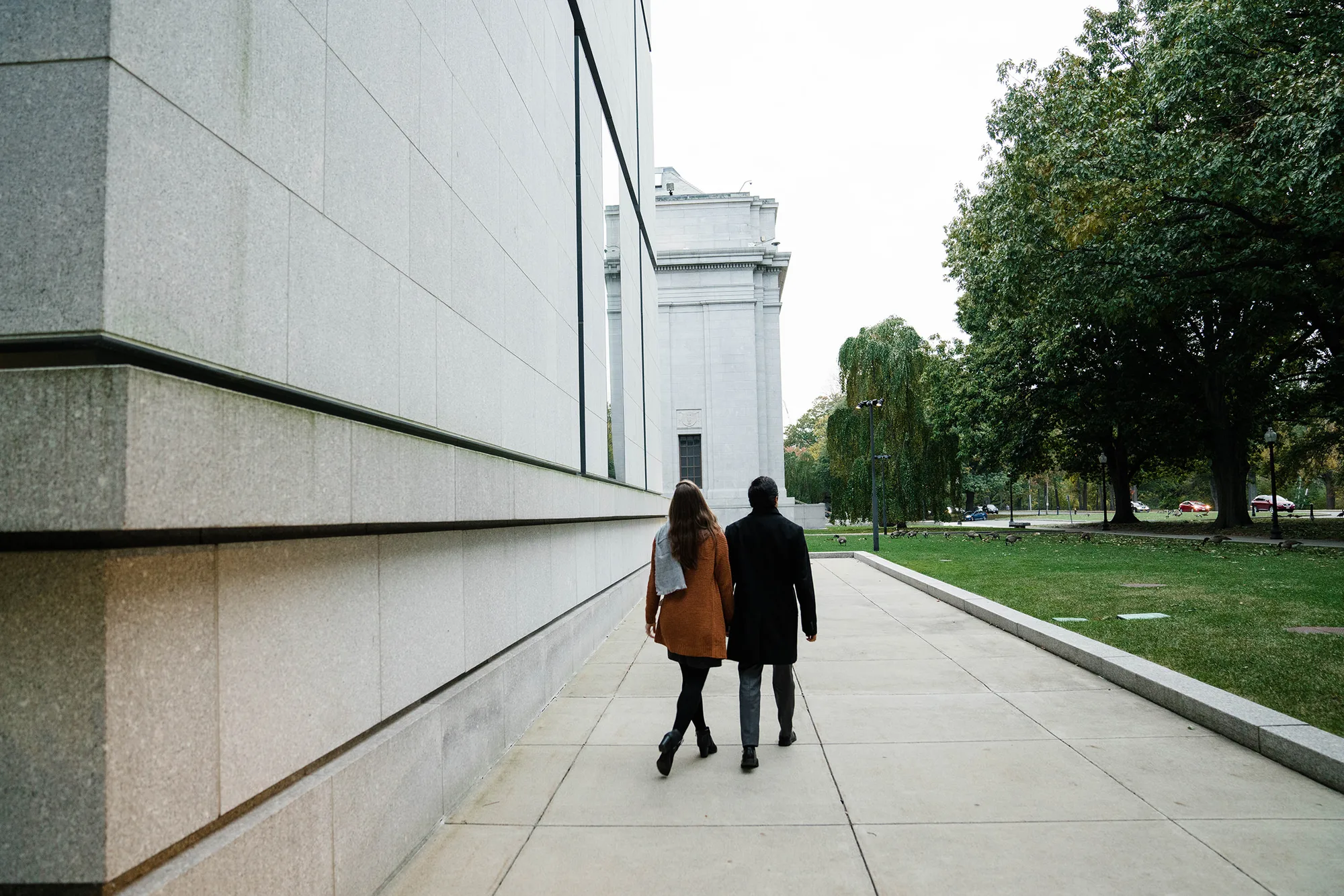 A best of Boston engagement photograph of couple walking by the Boston Museum of Fine Arts during their date night engagement session