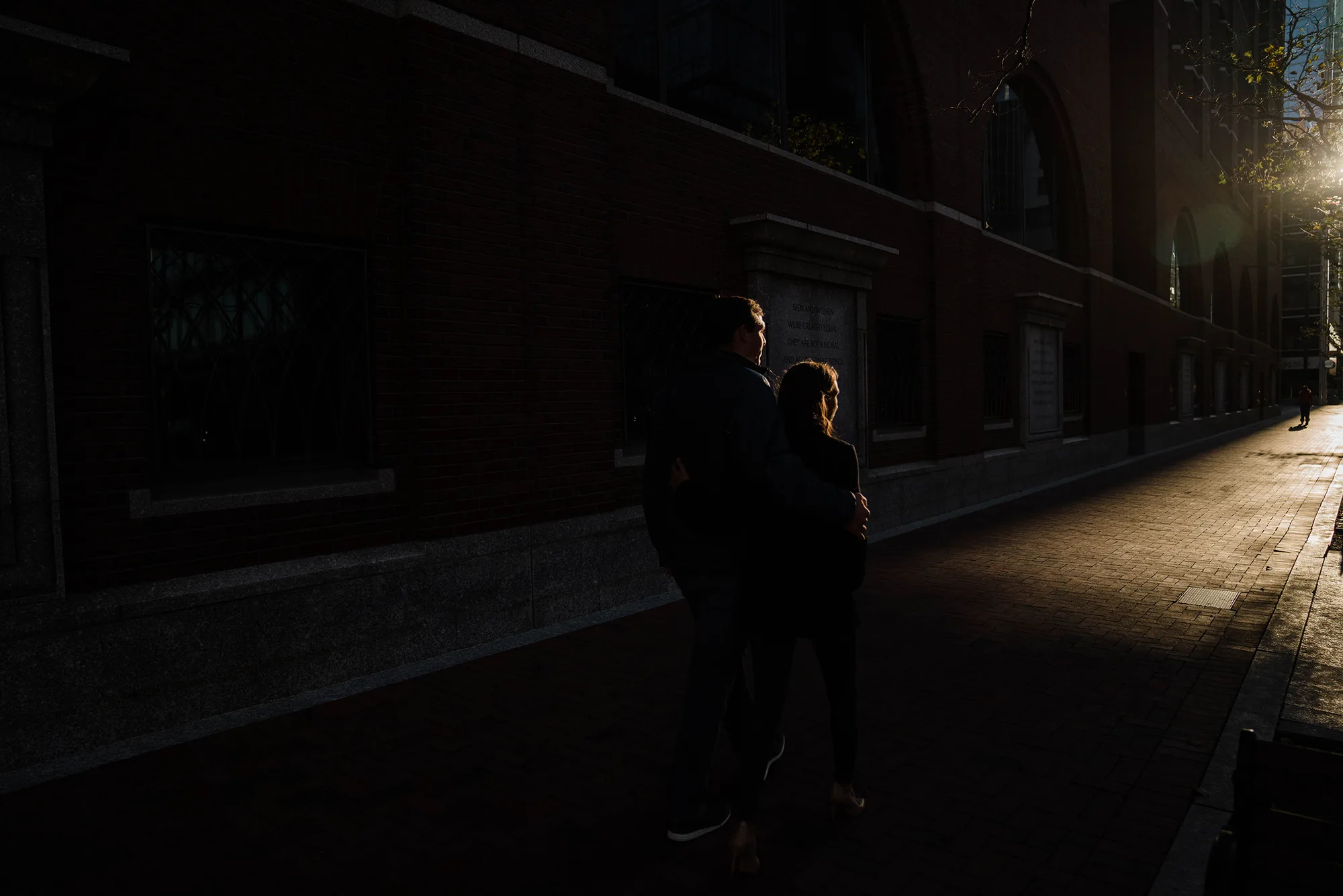 A documentary photograph of a couple walking down the street during their sunrise engagement session