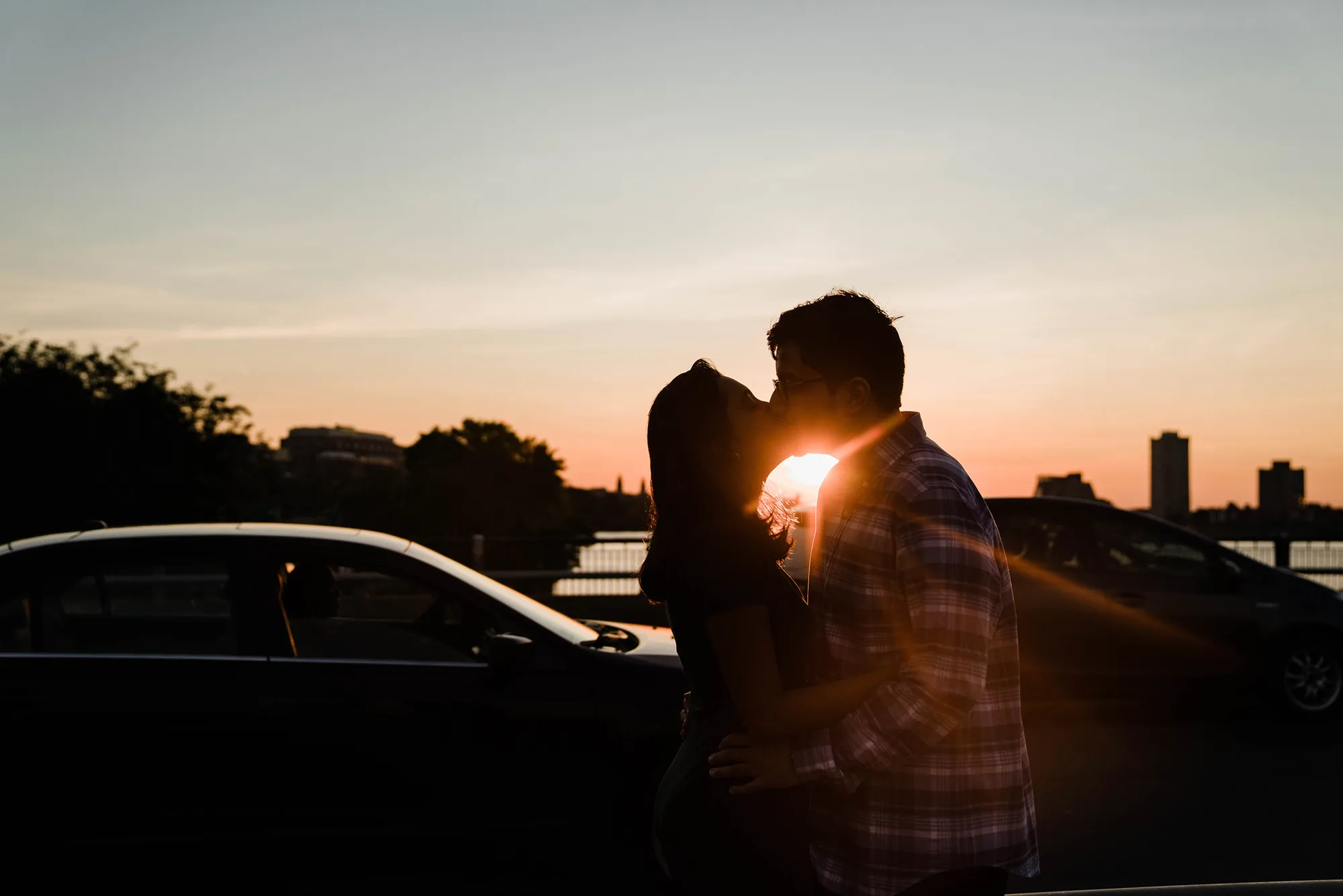 A best of Boston engagement photograph of a couple kissing on the Charles River bridge during a date night engagement session