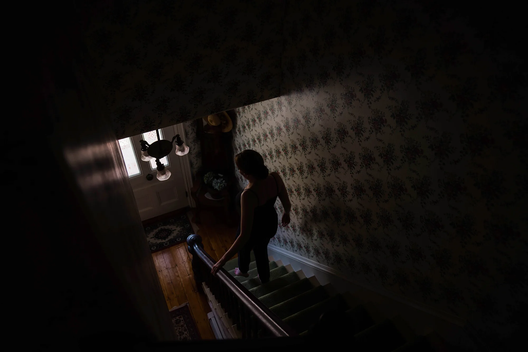 A documentary photograph featured in the best of wedding photography of 2019 showing a bride walking down the stairs at home