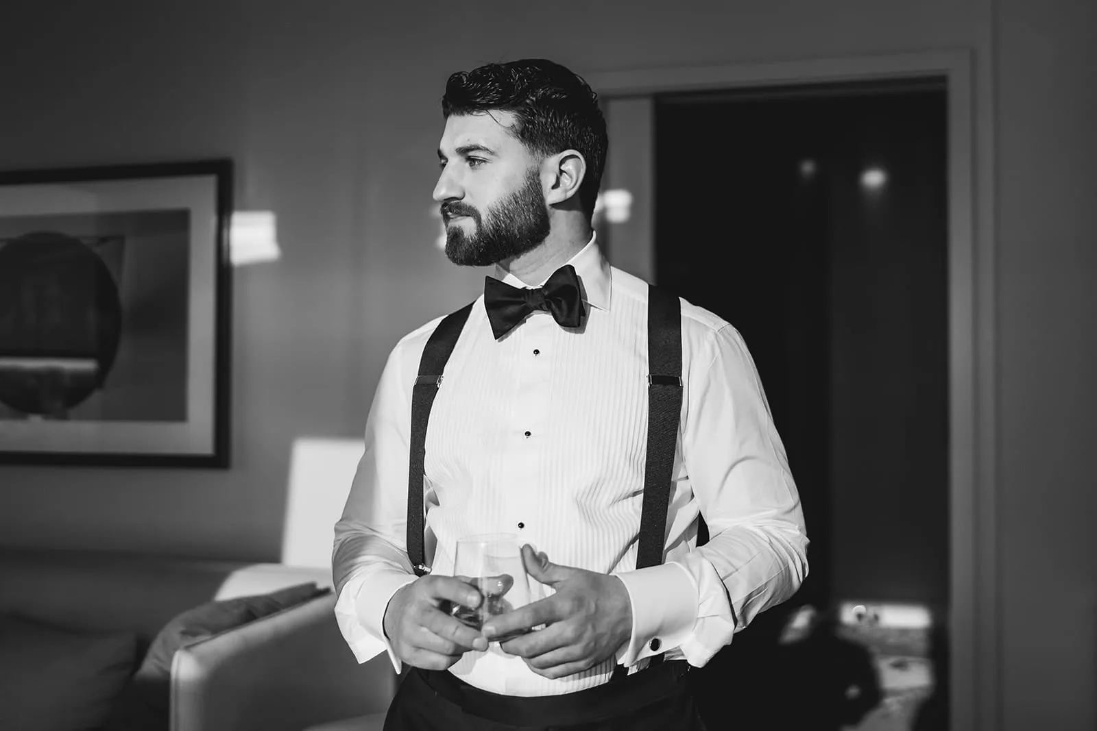 A documentary photograph of a groom getting ready at Omni Seaport before his ceremony at Boston City Hall and intimate wedding at Mooo.... Seaport.