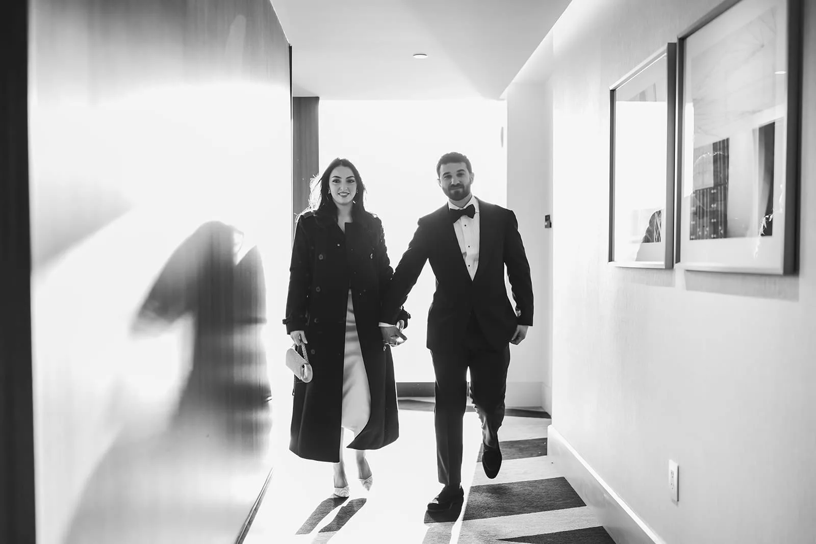 A documentary photograph of a bride and groom walking down the hall of the Omni Seaport before their wedding ceremony at Boston City Hall and their intimate wedding at Mooo.... Seaport.