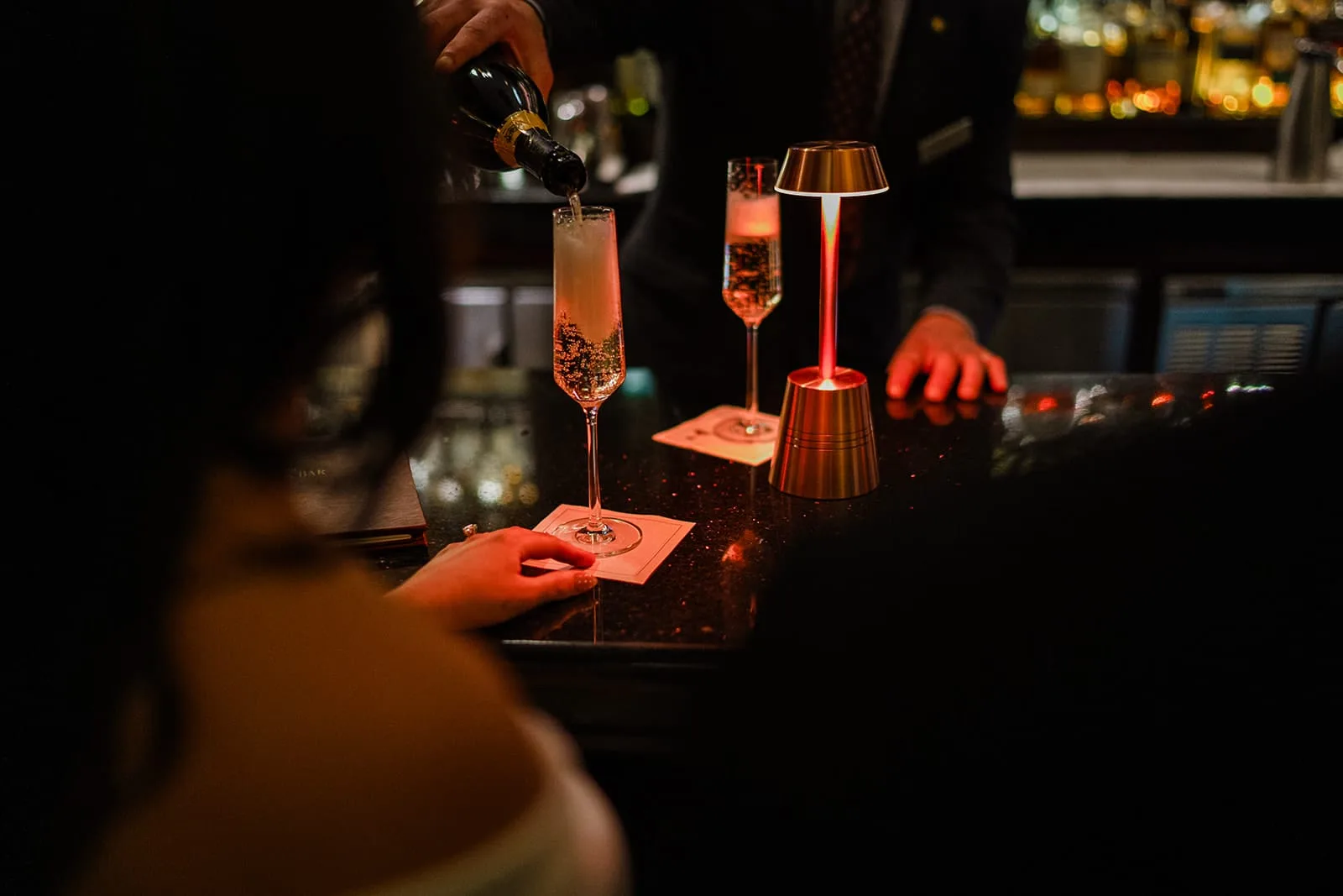 A documentary photograph of a bride and groom having champagne at The Dark Bar before their intimate wedding at Mooo.... Seaport.