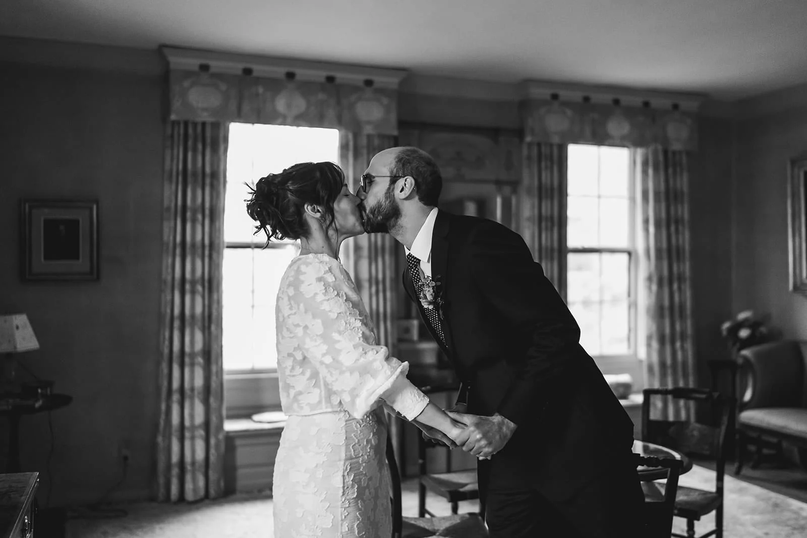 A documentary photograph of a bride and groom seeing each other and sharing a kiss during their Loring Greenough House Wedding.