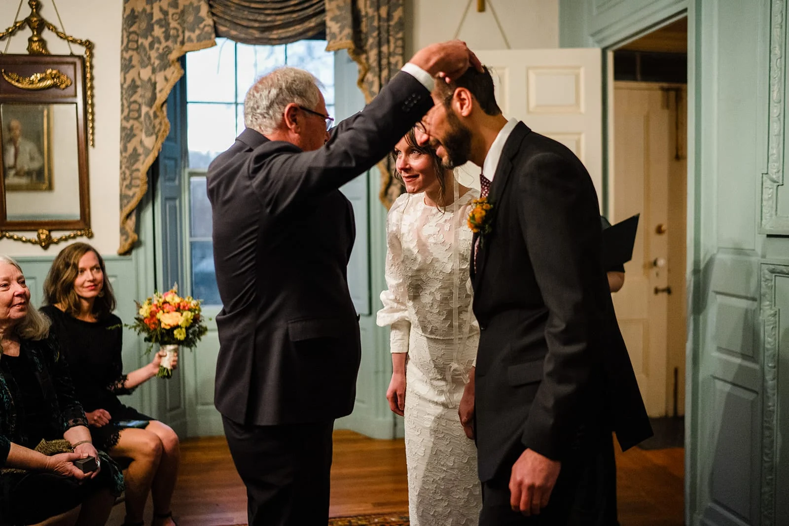A documentary photograph of a bride and groom incorporating greek traditions during their Loring Greenough House Wedding ceremony.