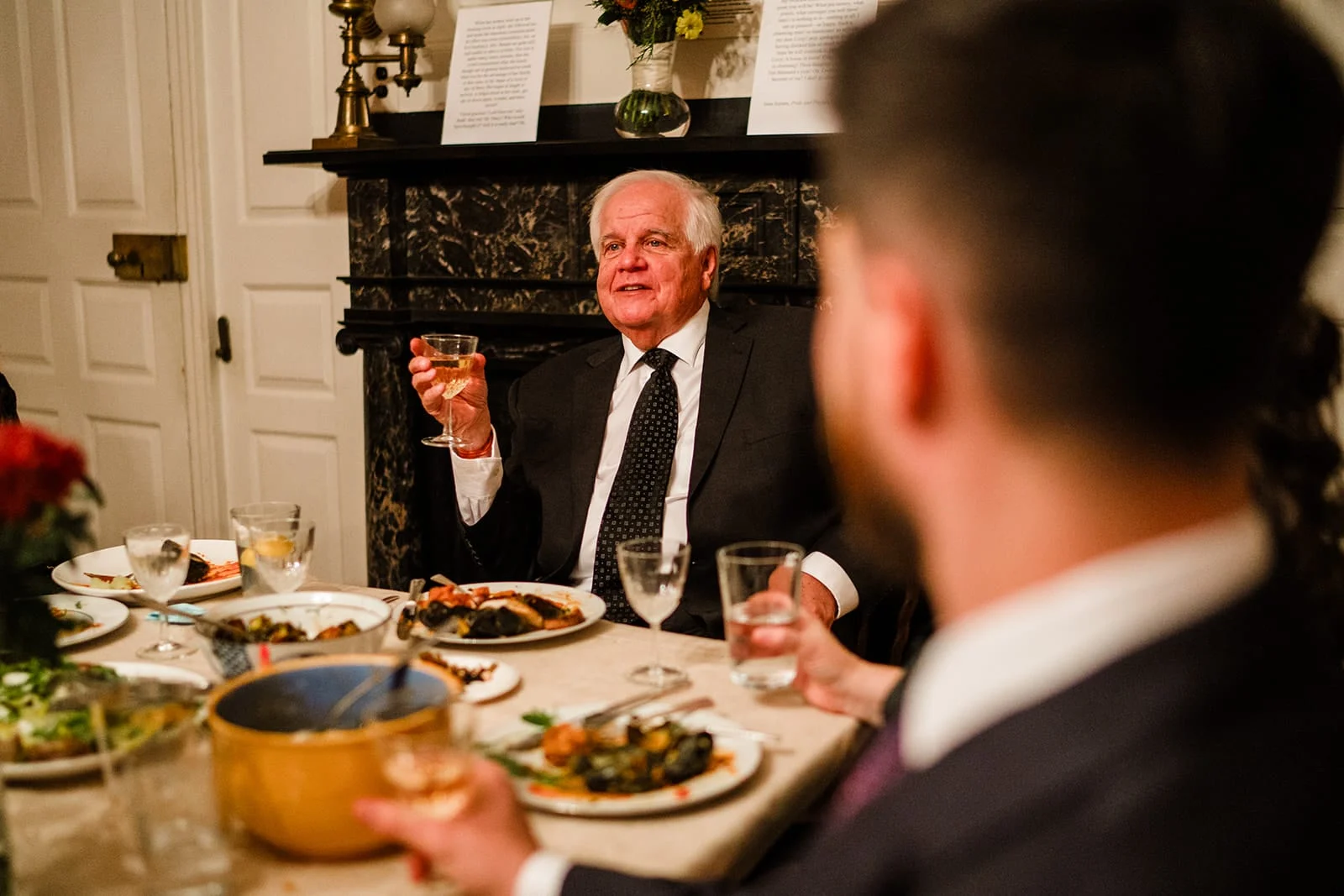 A documentary photograph of the bride's father making a toast during the dinner portion of their Loring Greenough House Wedding.