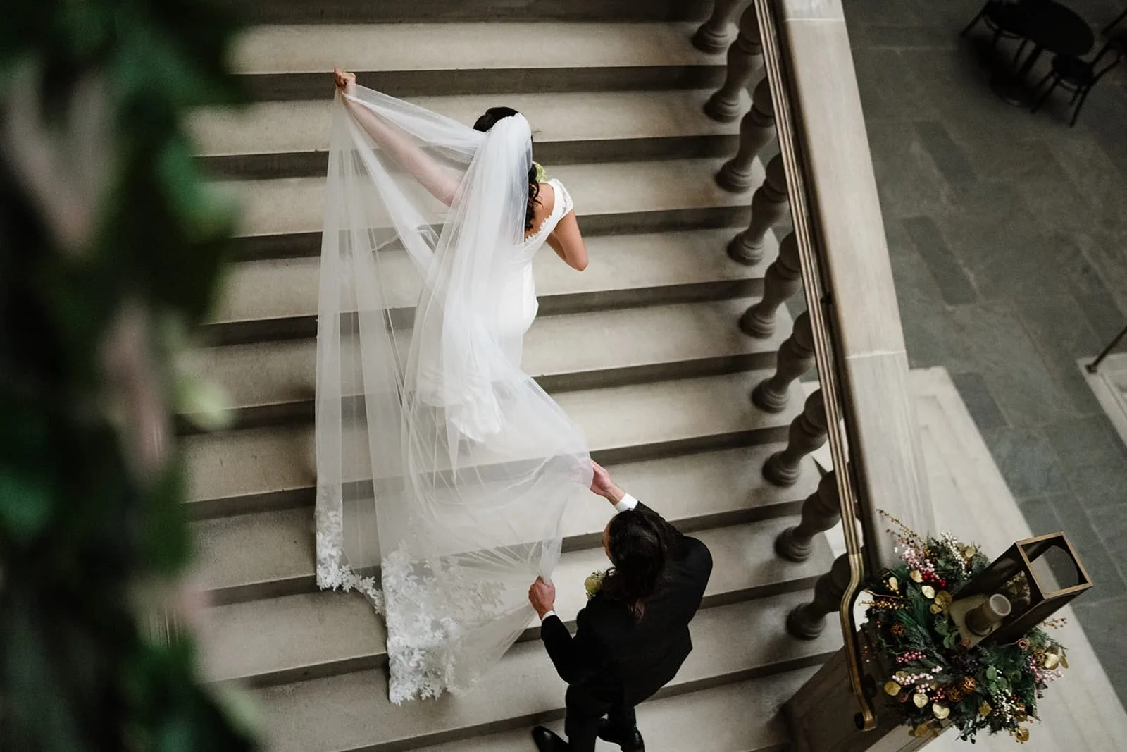 A documentary photograph of a bride and groom walking upstairs to the art galleries during their intimate Worcester Art Museum Wedding