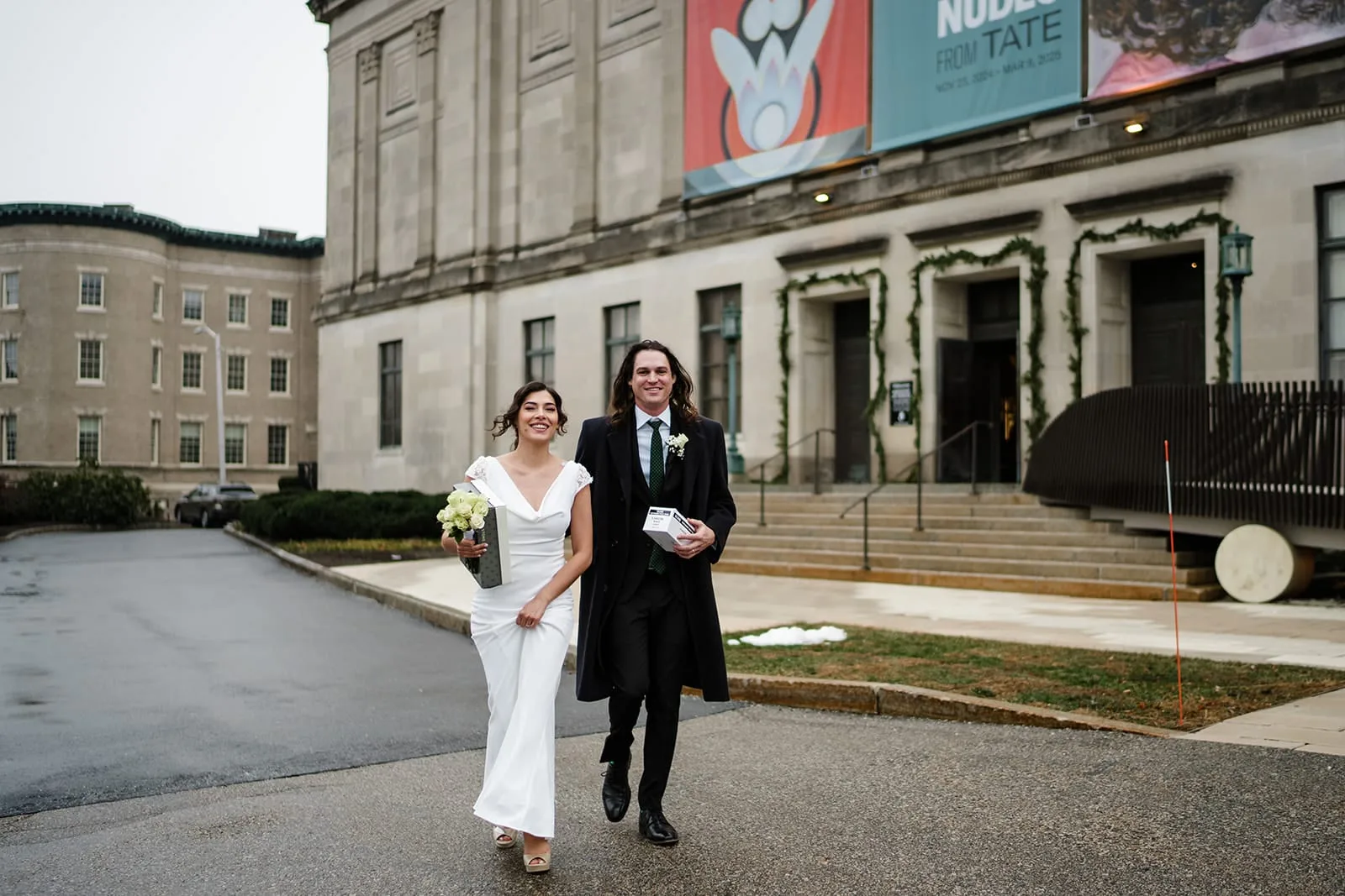 A documentary photograph of a bride and groom heading outside  during their intimate Worcester Art Museum Wedding