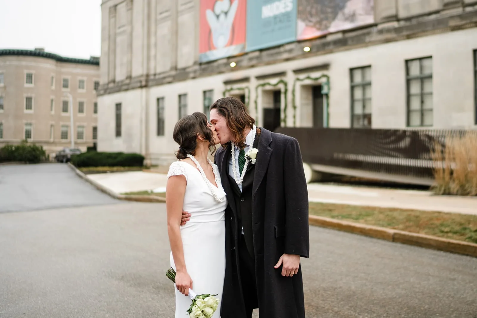 A documentary photograph of a bride and groom kissing outside  during their intimate Worcester Art Museum Wedding
