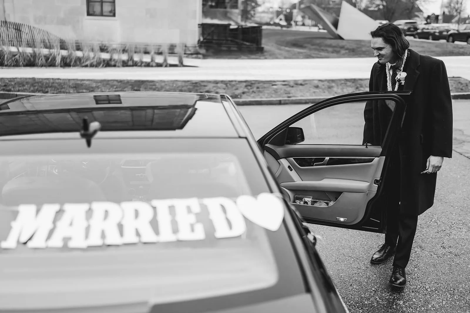 A documentary photograph of a bride and groom getting into the car after their intimate Worcester Art Museum Wedding
