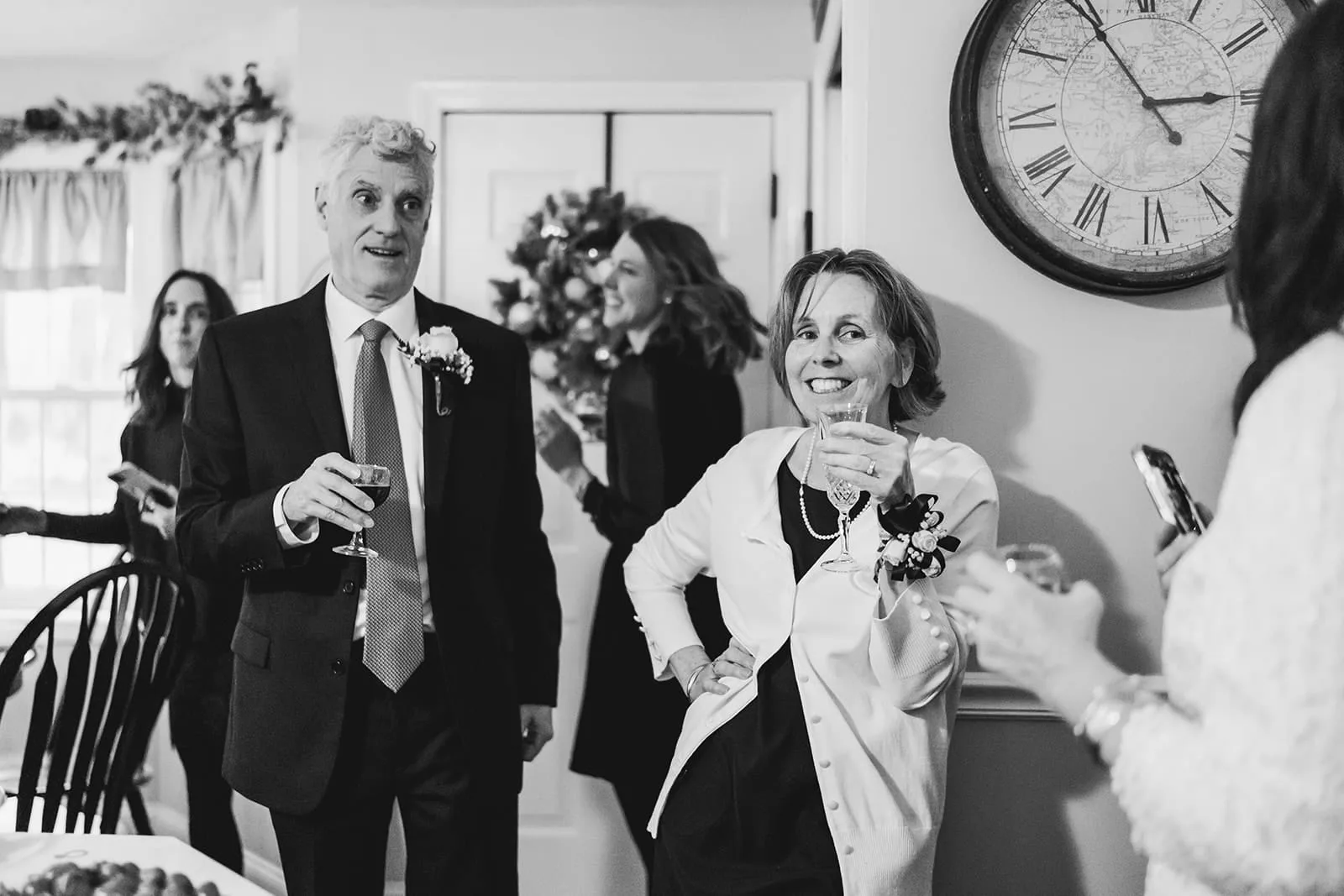 A documentary photograph of guests laughing during a in home celebration after their intimate Worcester Art Museum Wedding ceremony