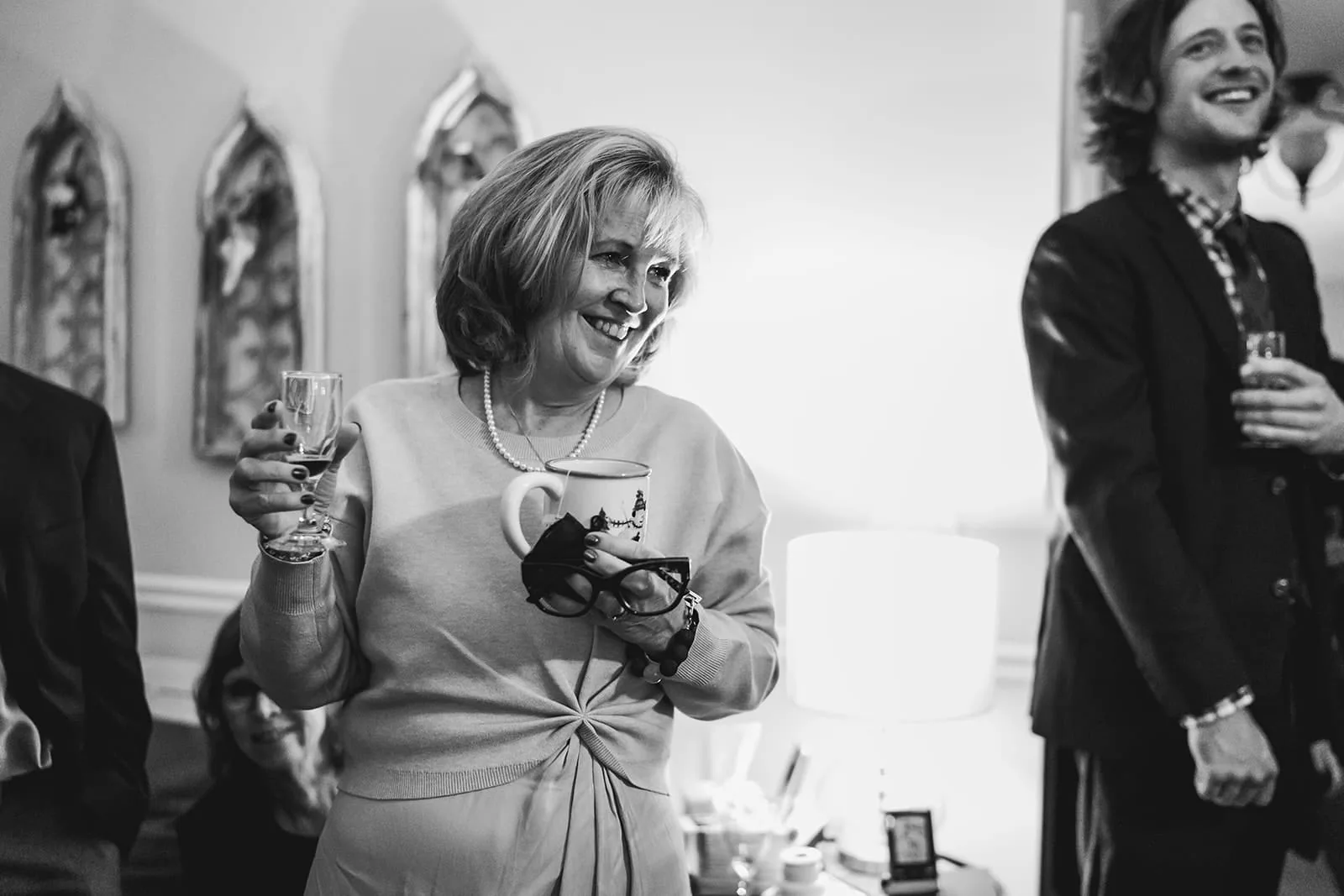 A documentary photograph of guests laughing during a in home celebration after their intimate Worcester Art Museum Wedding ceremony
