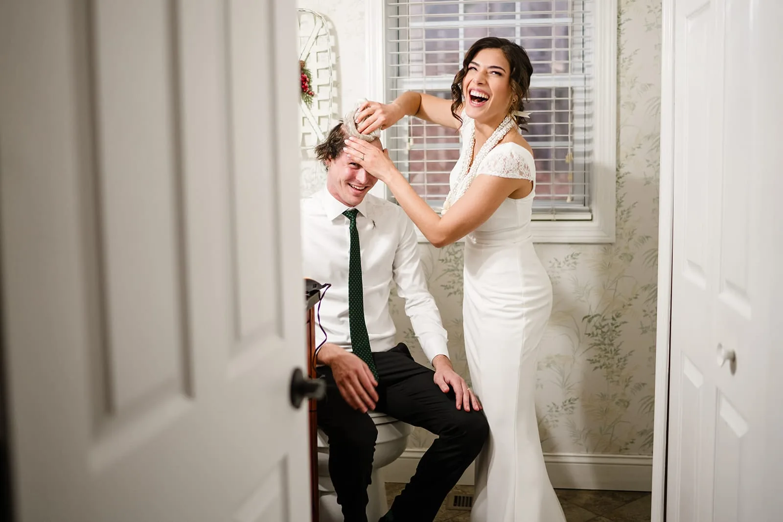 A documentary photograph of a bride shaving a groom's head before cancer treatment during a in home celebration after their intimate Worcester Art Museum Wedding ceremony