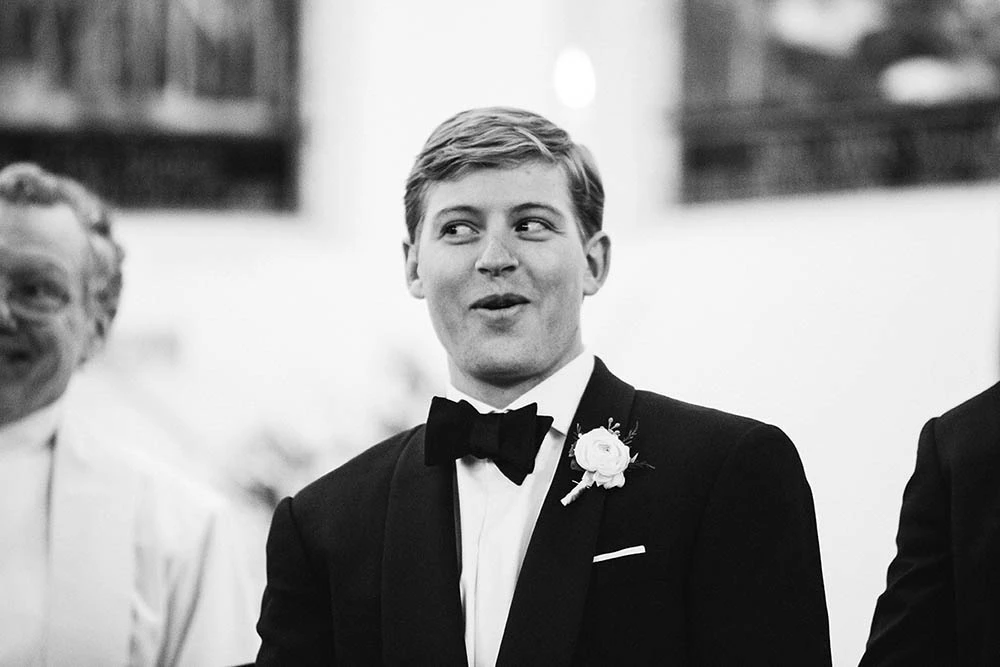 A groom in a bow tie looking up in surprise