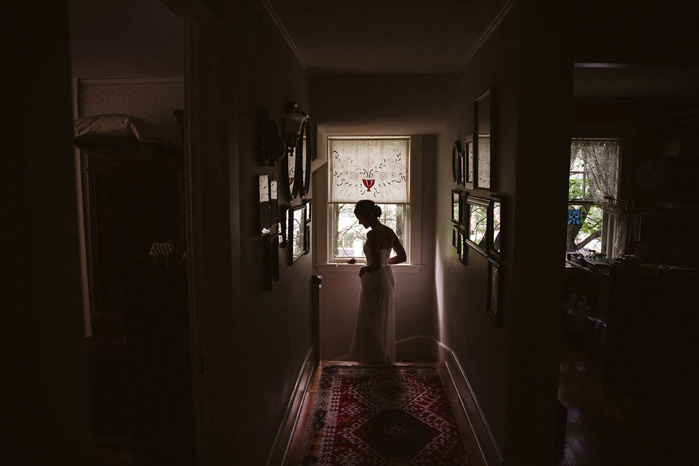 A bride's silhouette at the end of a dark hallway