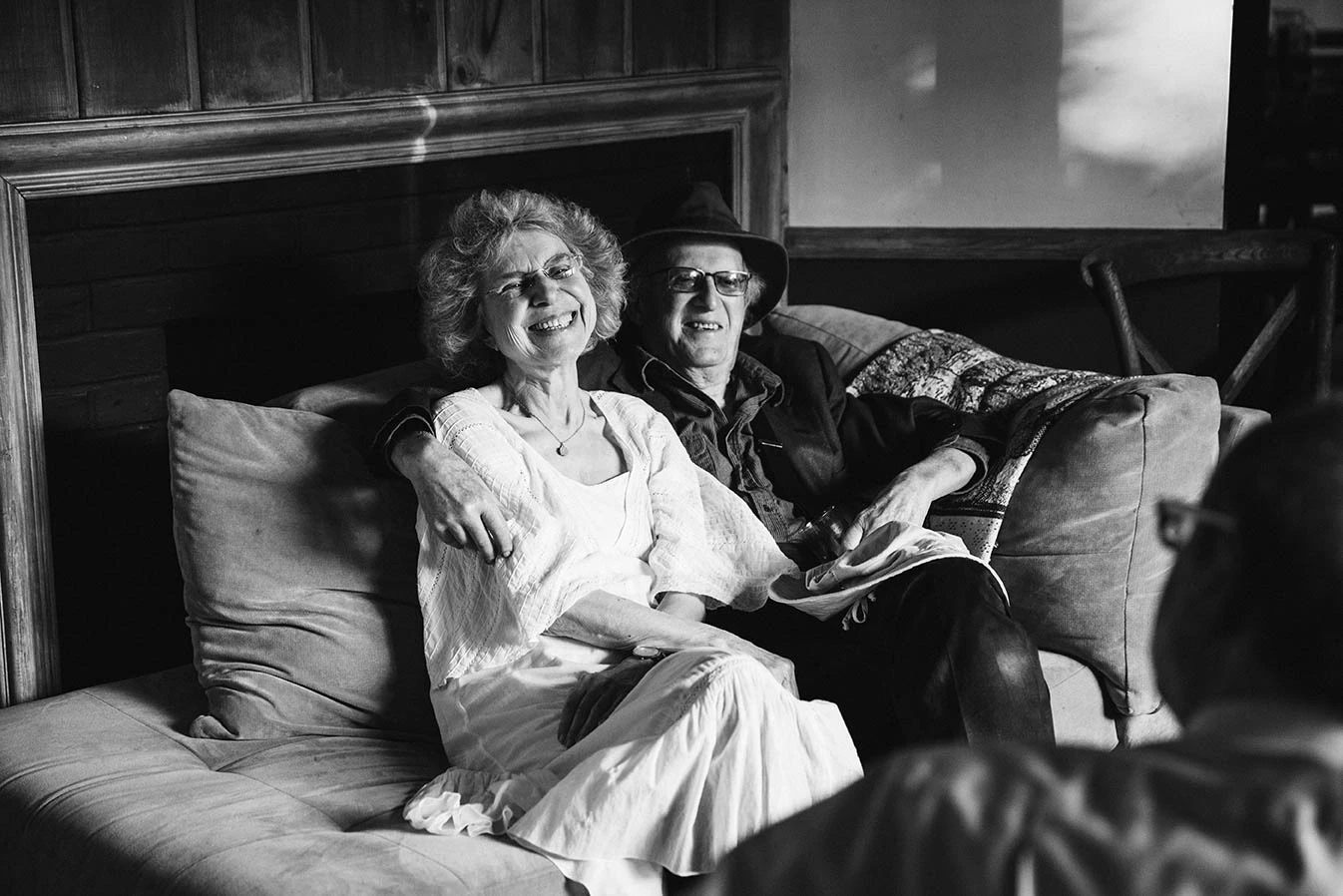An older couple laughing on a sofa