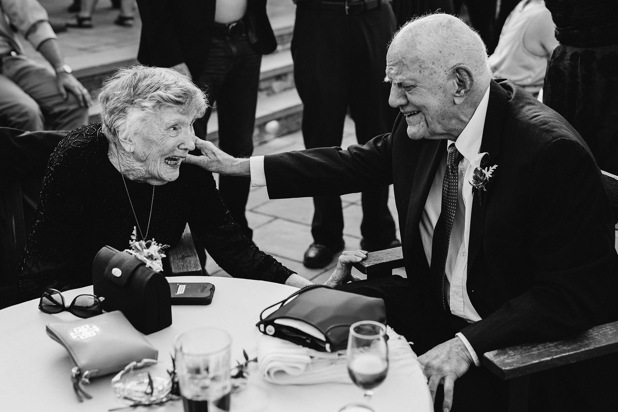An older woman and man laughing across a table