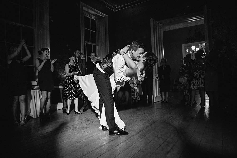 A groom dipping the bride for a kiss on the dance floor