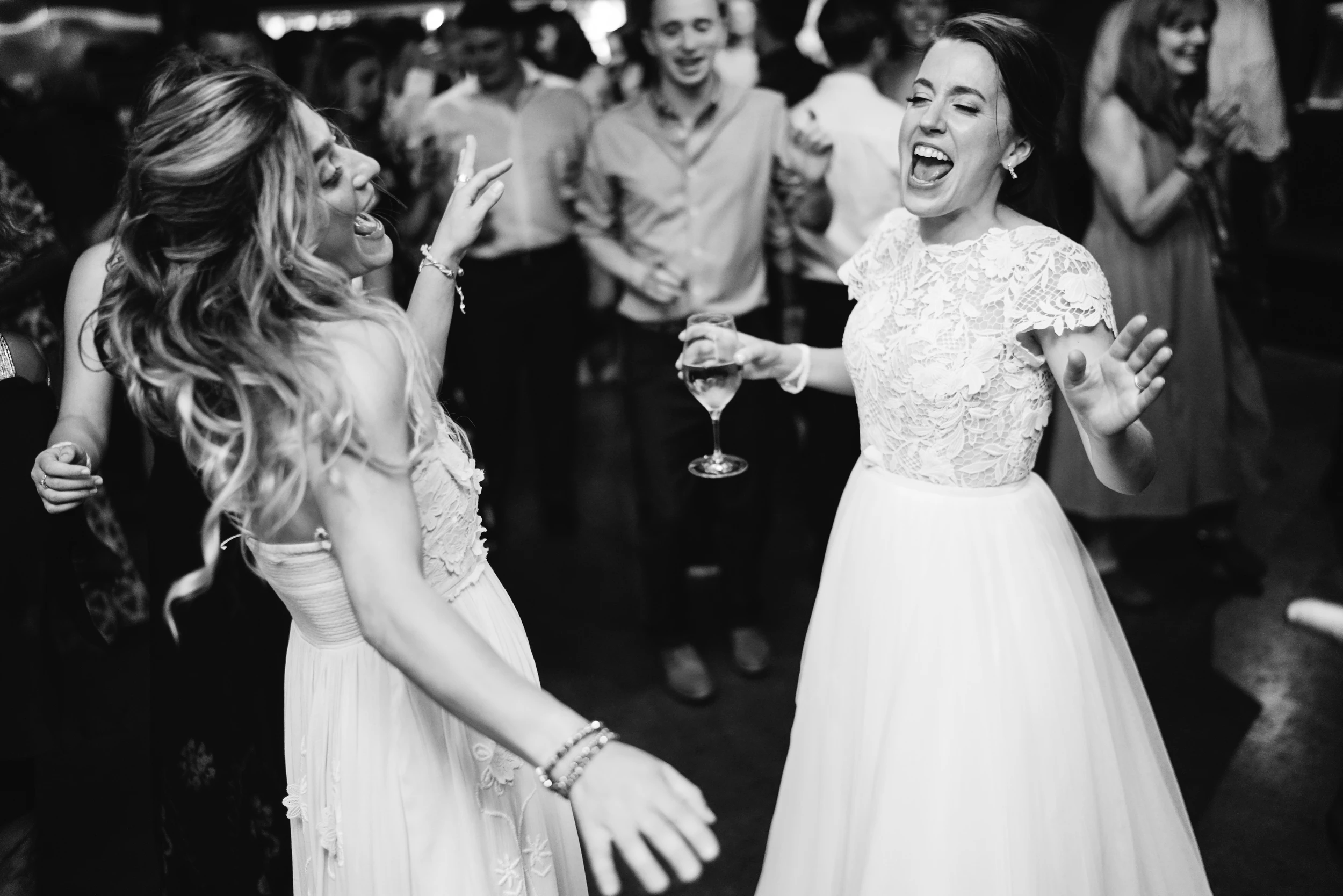 Two women dancing and laughing among the guests