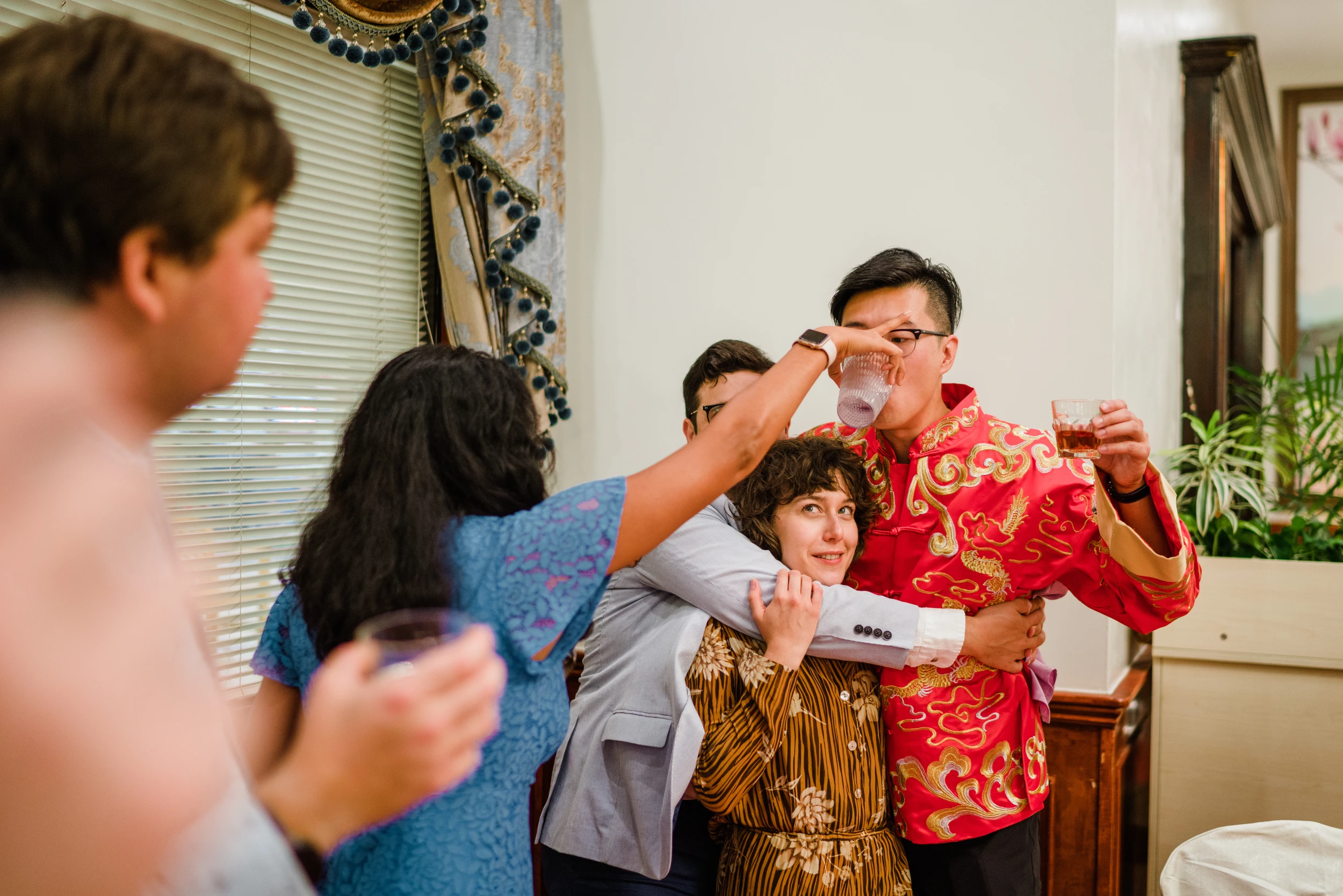 Family toasting at home, an older man in a red shirt laughing
