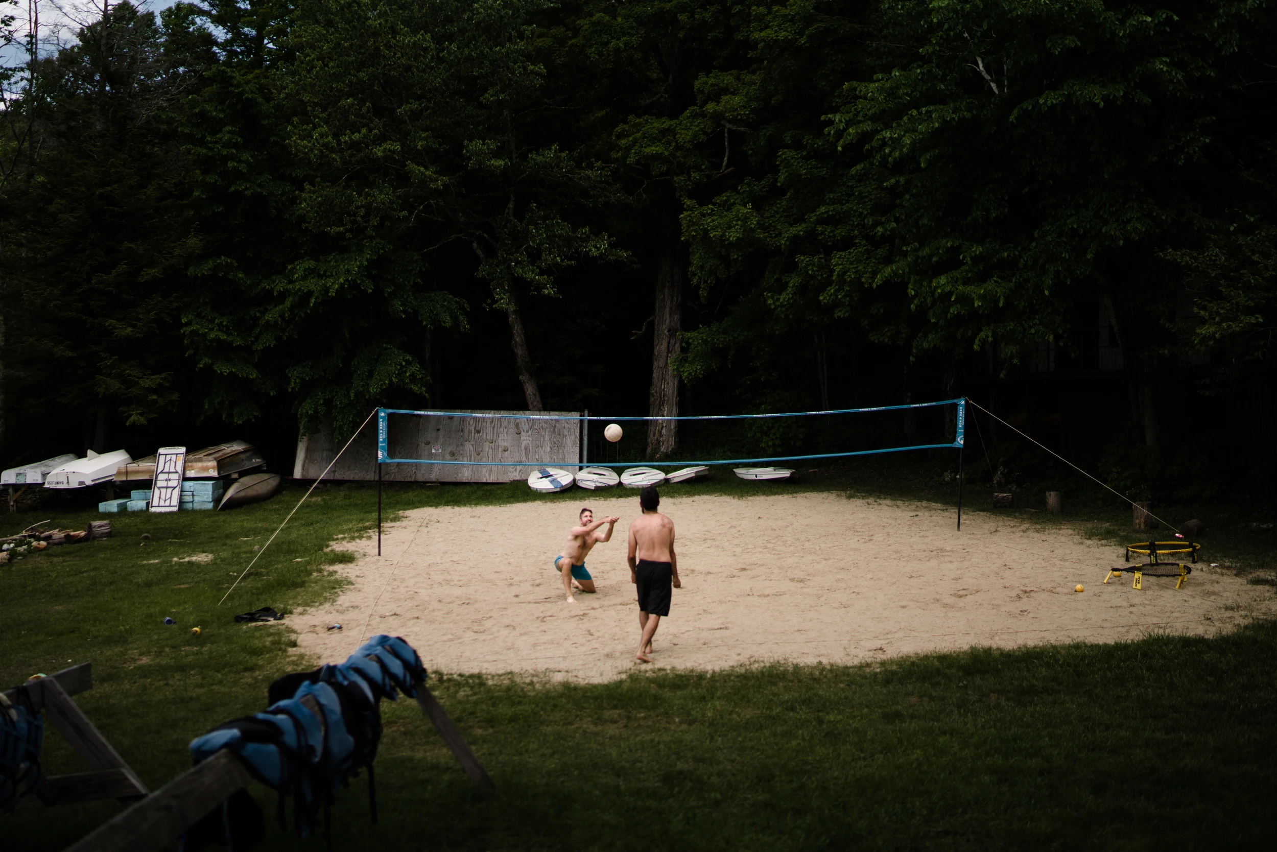 A game of volleyball on a sand court at a summer camp