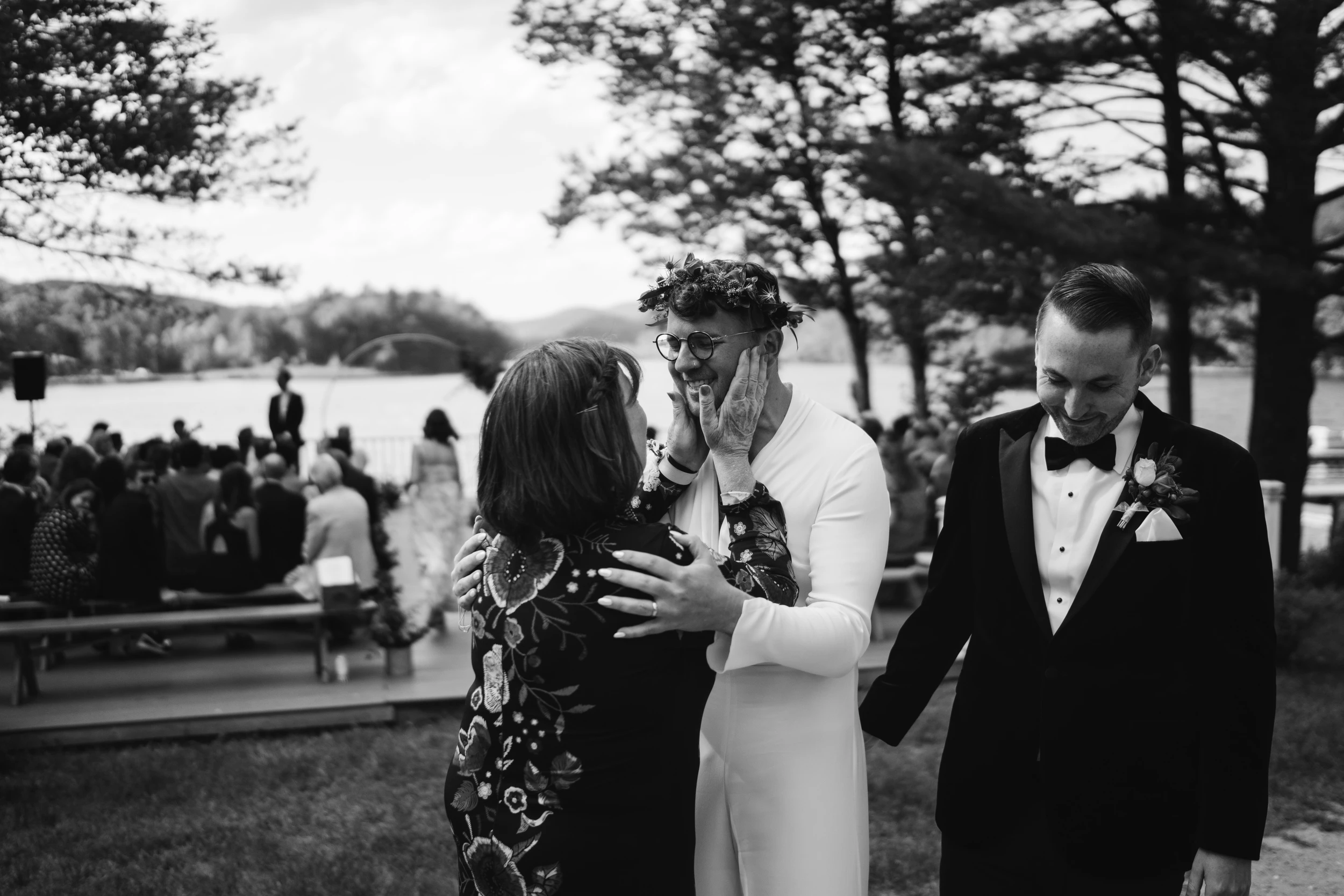 Guests embracing at a lakeside ceremony